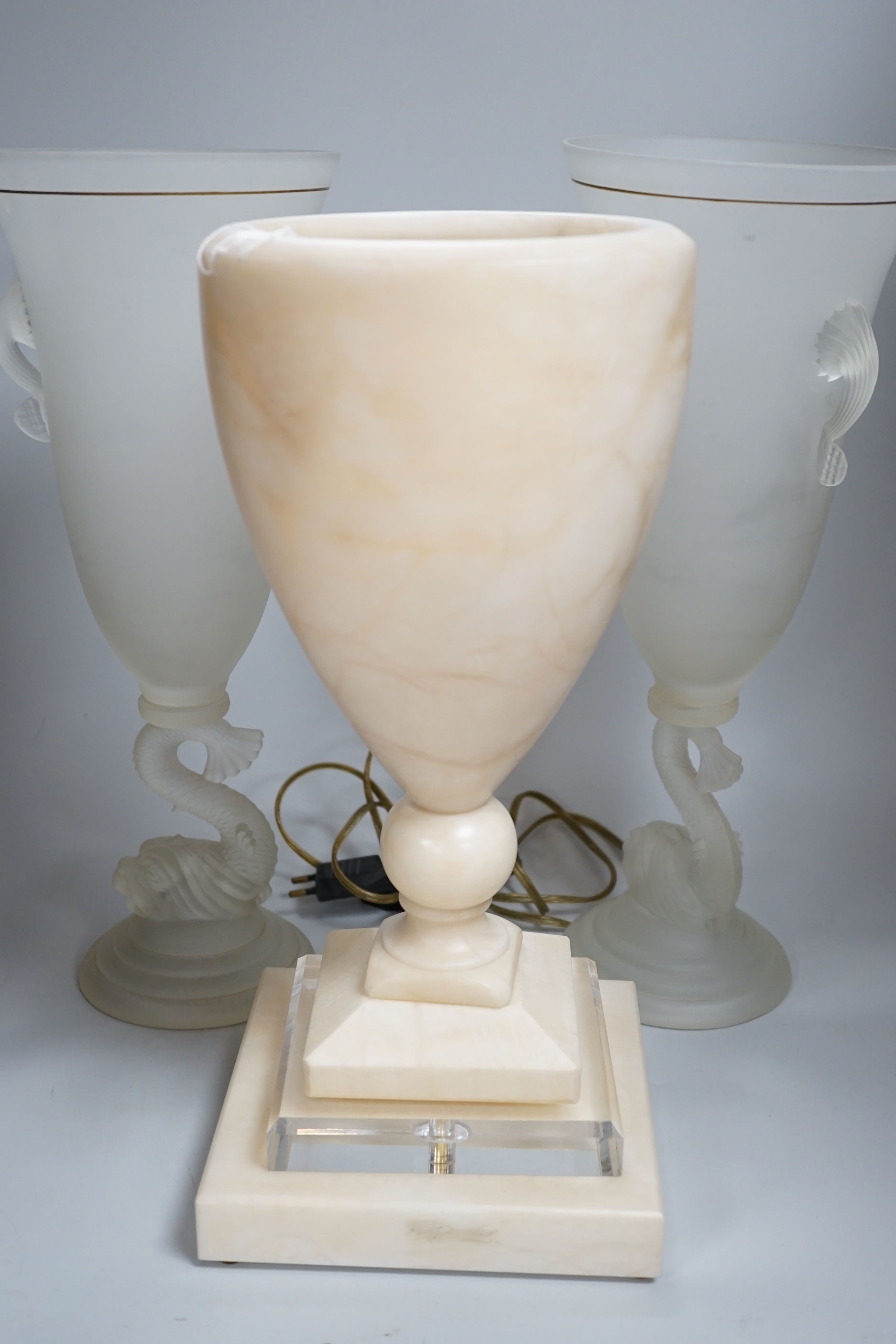 A glass uplighter table lamp in the style of alabaster and two frosted glass dolphin vases